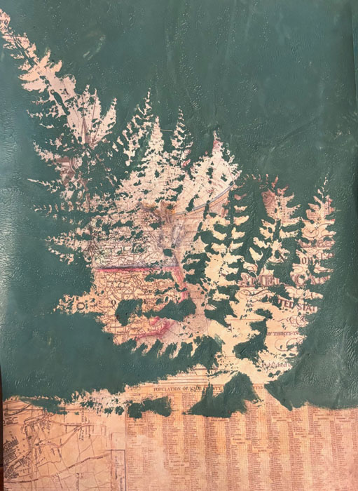 Painting on a map page showing a pointed leaf in the negative space.